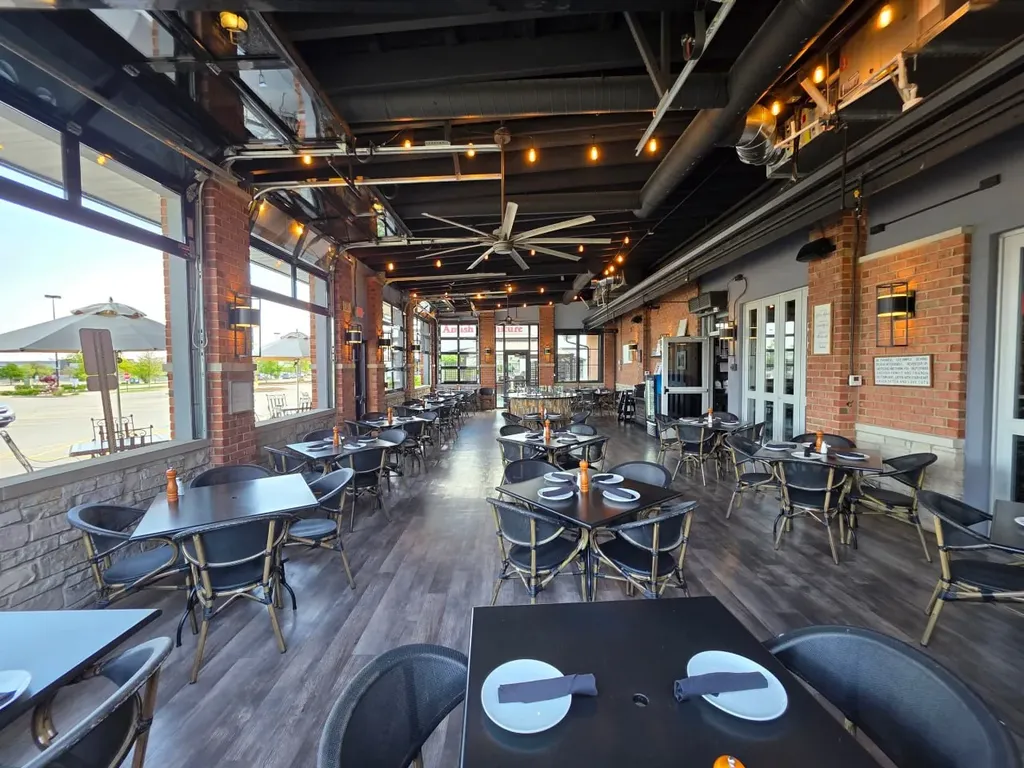 Restaurant interior with open-air patio and industrial lighting