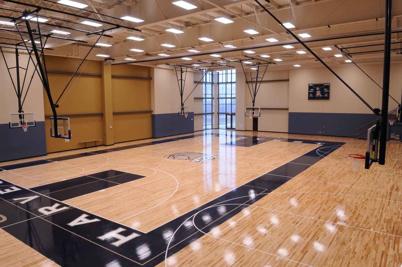 Gymnasium with hardwood basketball court and scoreboard