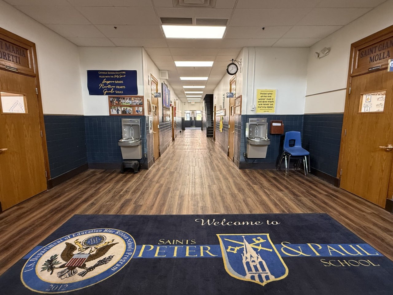 School hallway entrance with blue tiled walls and welcome mat