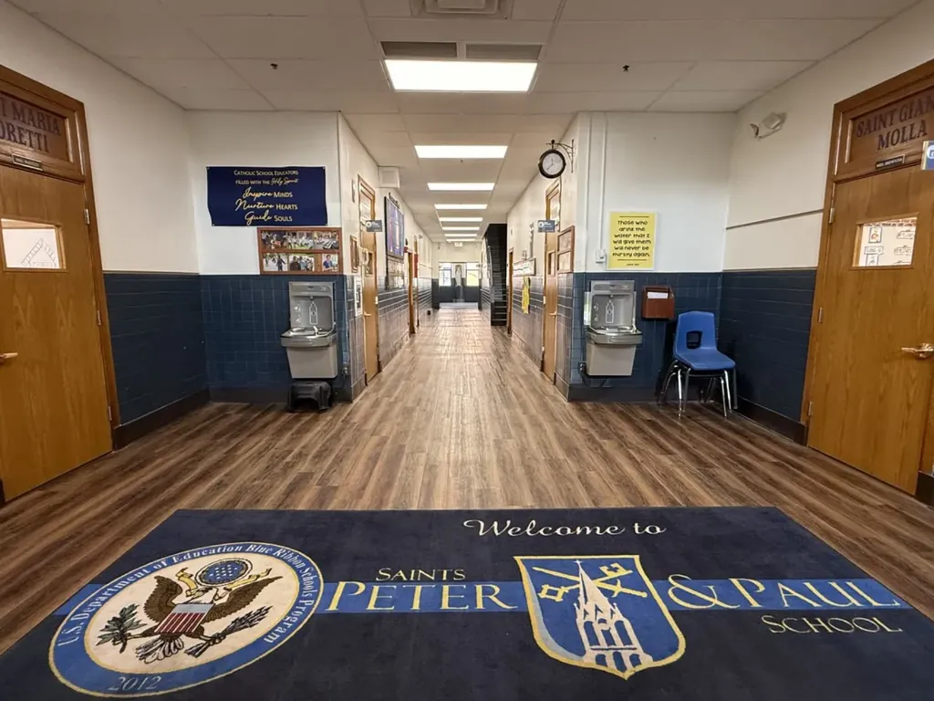 School hallway entrance with blue tiled walls and welcome mat