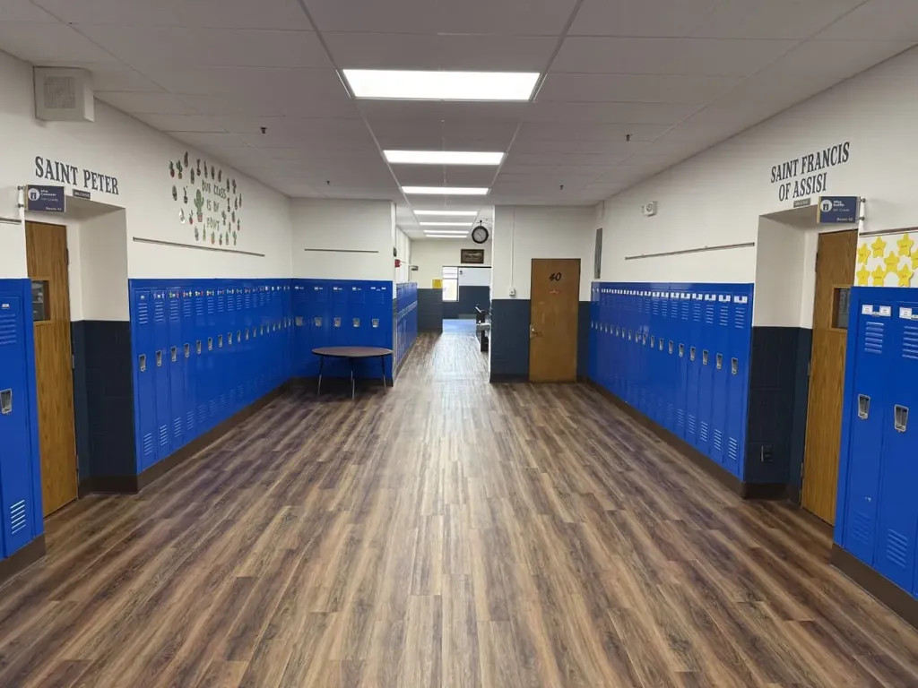 School hallway with blue lockers and Saint Peter and Saint Francis of Assisi signage