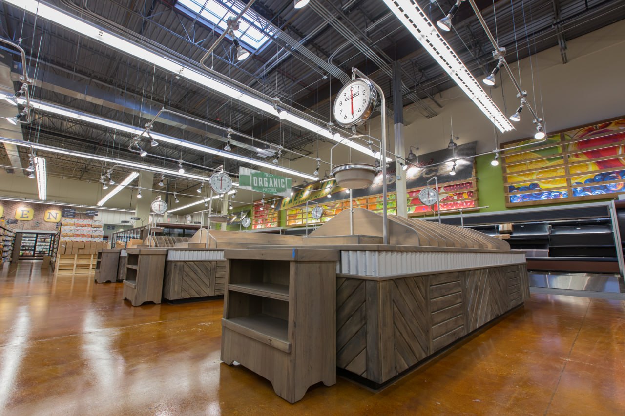 Supermarket produce section with multi-tiered wooden FRESH ORGANIC display