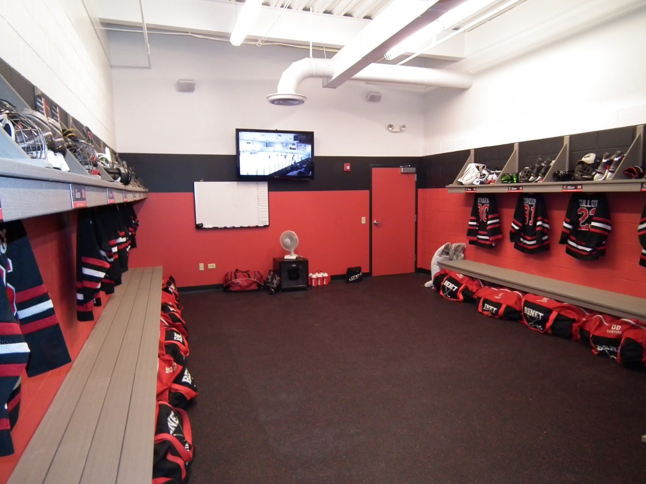 Team locker room with jerseys and mounted display screen