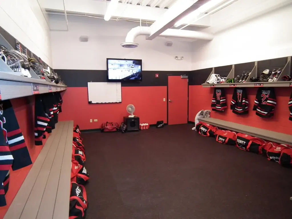 Team locker room with jerseys and mounted display screen