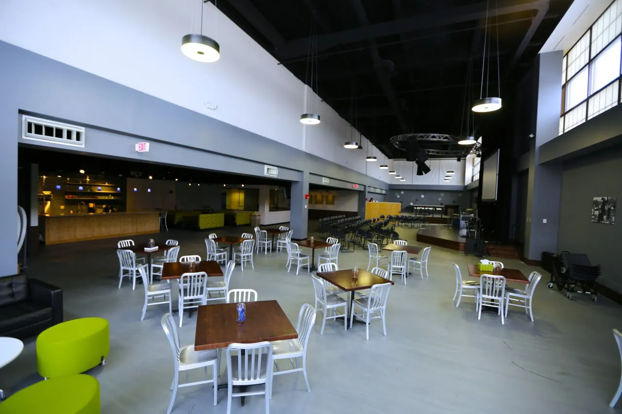 Event room at the Highpoint Naperville teen center, set up with tables, chairs, and a stage