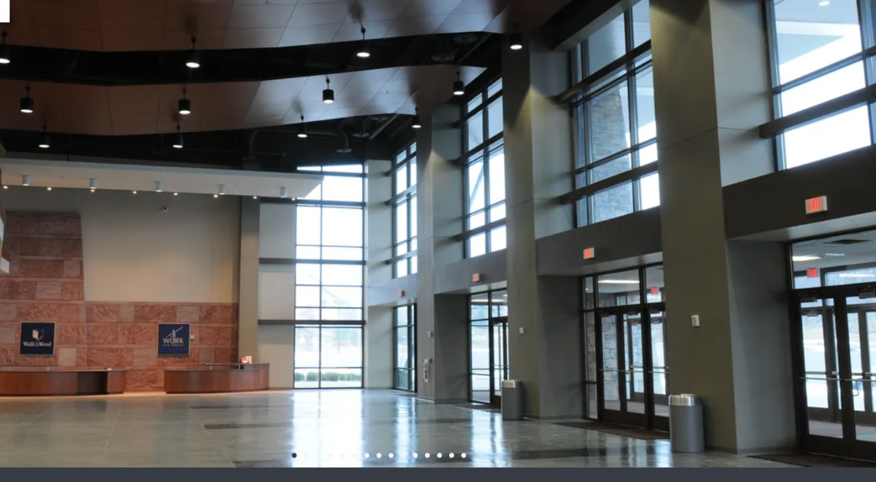 Modern institutional entrance hall with stone walls and glass doors