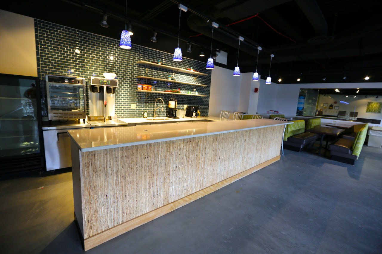 Modern office break room with bar counter and data display