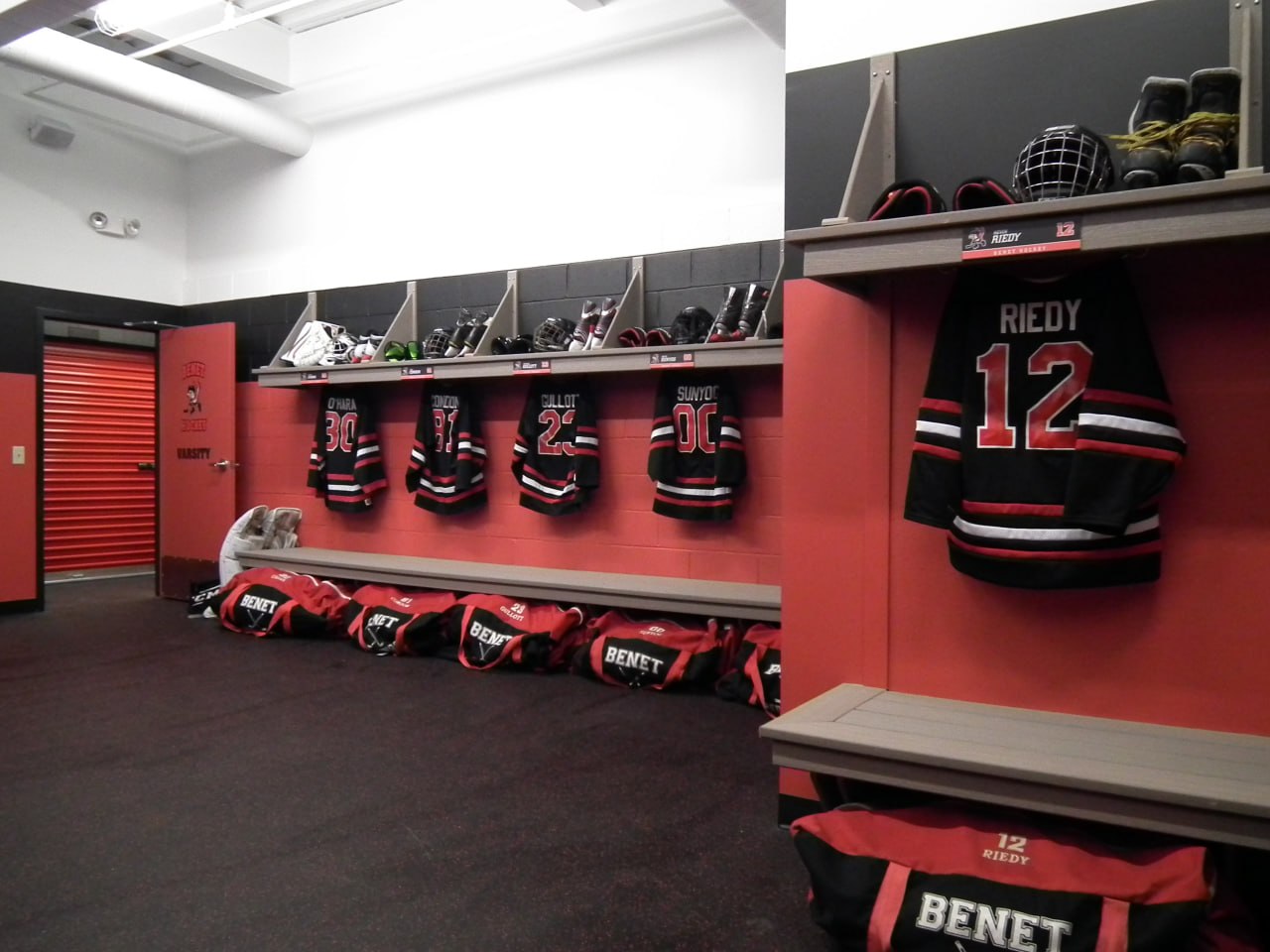 Benedictine Riedys team locker room with red lockers and jerseys